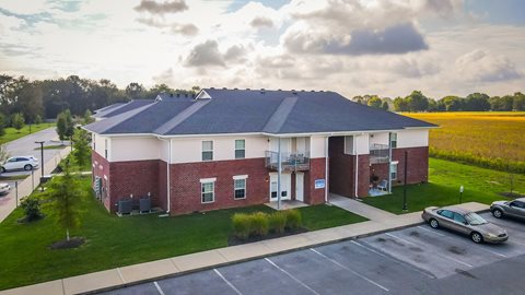 an aerial view of a brick building with cars parked in a parking lot